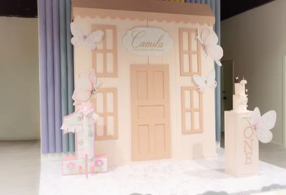 Full pastel playhouse backdrop with butterfly cutouts and cake pedestal
