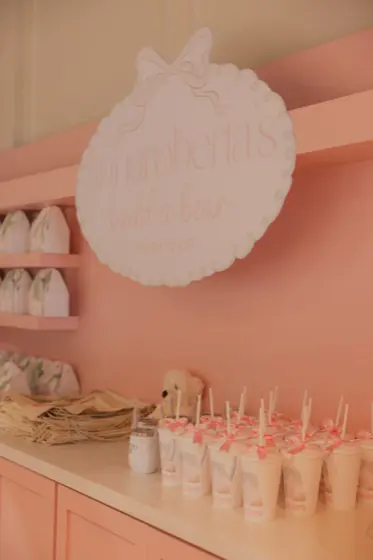 Build-a-bear workshop counter with a custom sign and personalized drink cups