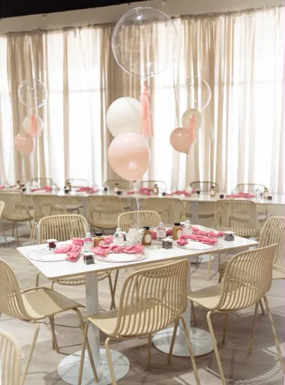 Adult seating area at Playville with balloon centerpieces and sheer curtains
