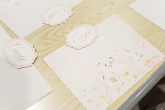Custom floral placemats and personalized name tags on a kids' party table