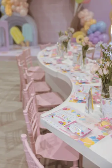 Kids' place settings with themed activity cards, favor bags and fresh flowers